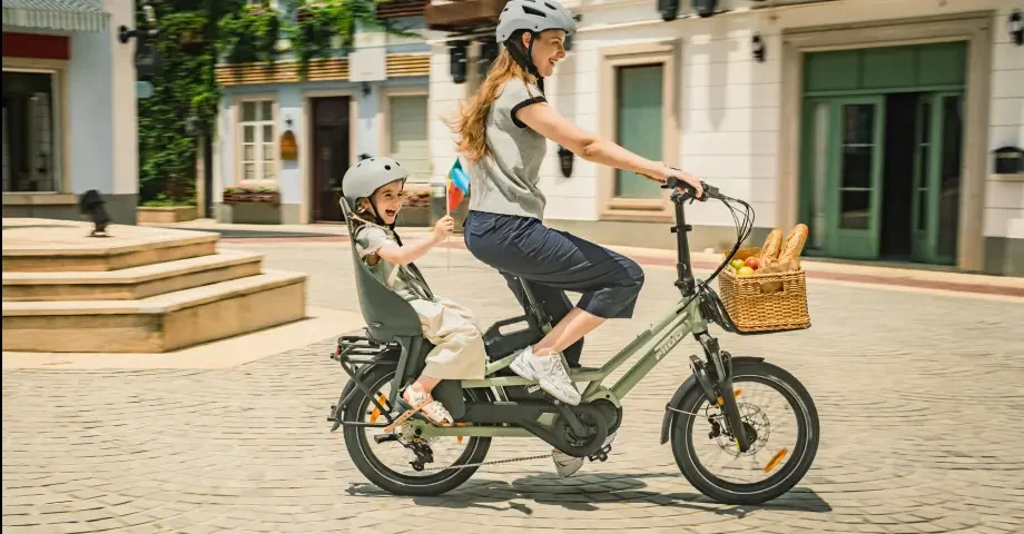 Parent et enfant sur un vélo électrique familial cargo en ville